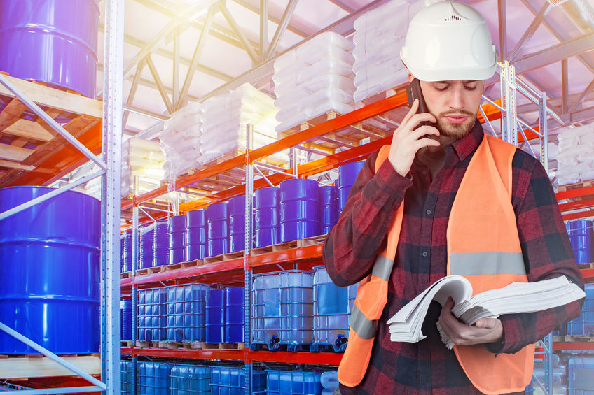 The storekeeper on the background of the warehouse. Blue barrels The storekeeper on the background of the warehouse. Blue barrels